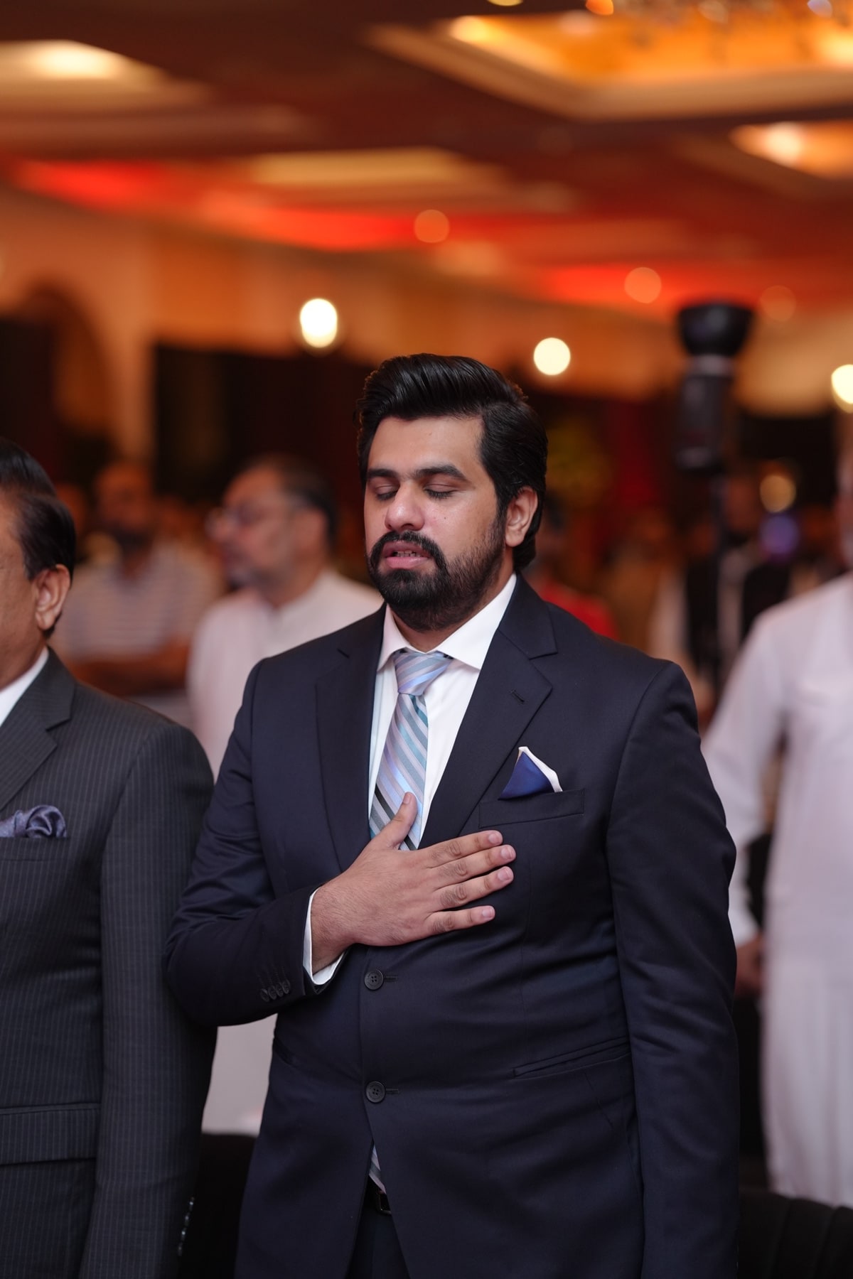 A guest standing with his hand over his heart during the national anthem